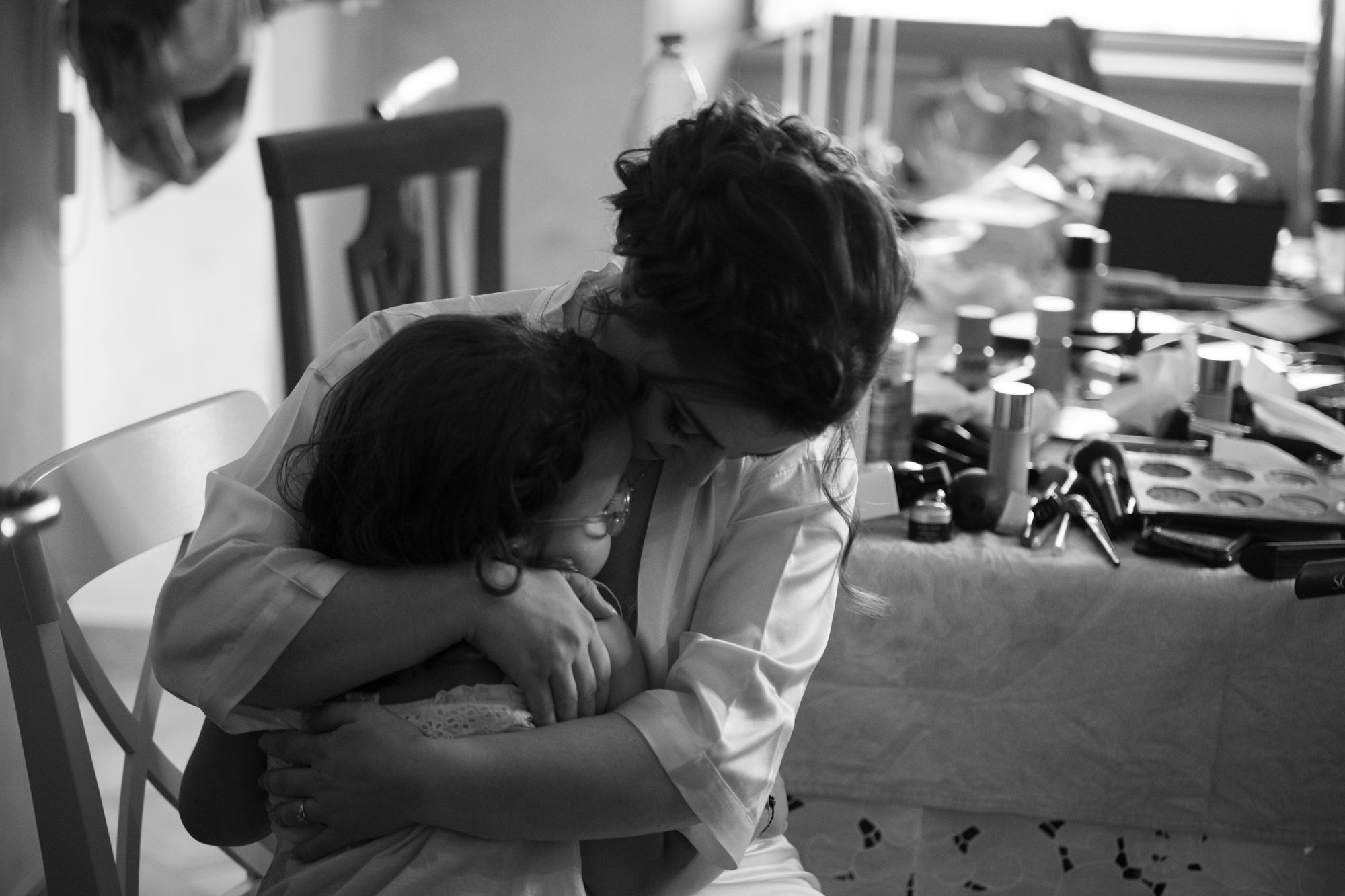 A black and white moment of a bride hugged tightly before the ceremony